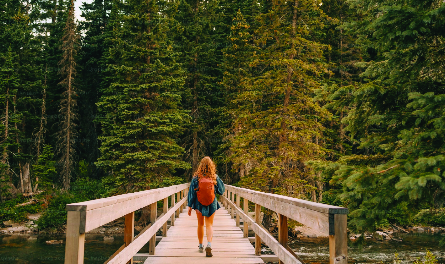 Woman Walking Across a Wooden bridge over a river
